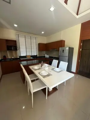 a kitchen with a white table with chairs and a refrigerator at 3 bedroom Vip Villa Rawai Phuket in Rawai Beach