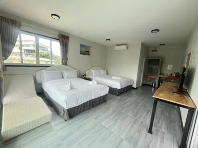 a hotel room with two beds and a couch at Lucky 9 Airport Hotel Phuket in Nai Yang Beach