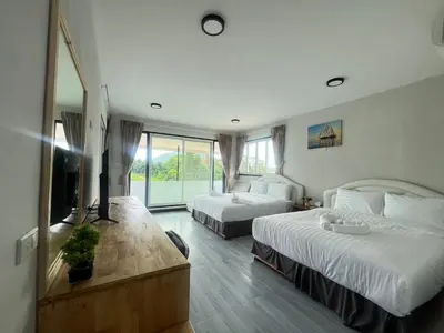 a hotel room with two beds and a television at Lucky 9 Airport Hotel Phuket in Nai Yang Beach