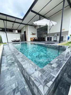 a swimming pool with blue water in a house at Sakhu Art Villa in Nai Yang Beach