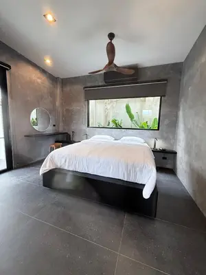 a bedroom with a large bed and a window at Sakhu Art Villa in Nai Yang Beach