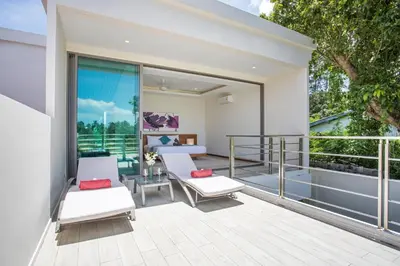 a balcony with white chairs and a table and a bed at Private Pool 4BR Villa Kari next to Rawai Beach in Rawai Beach