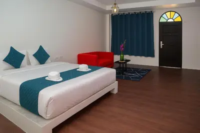 a bedroom with a bed and a red chair at Chic Boutique Hotel, Patong in Patong Beach