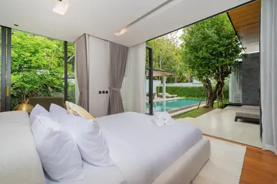 a bedroom with a white bed and a large window at Villa Beautiful swimming pool in Phuket