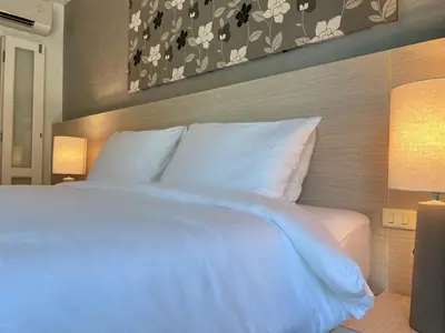 a bedroom with a large bed with white pillows at The Sealect Hotel in Kata Beach