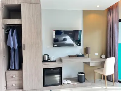 a living room with a tv above a fireplace at The Sealect Hotel in Kata Beach