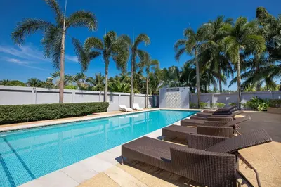 a swimming pool with lounge chairs and palm trees at 3BR Pool Access Villa near Mission Hills Golf - Argent 7 in Ban Muang Mai