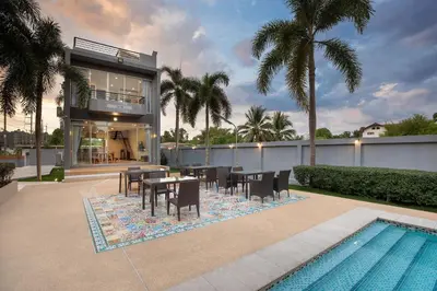 a house with a table and chairs next to a swimming pool at 3BR Pool Access Villa near Mission Hills Golf - Argent 7 in Ban Muang Mai