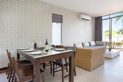 a dining room with a table and a couch at 3BR Pool Access Villa near Mission Hills Golf - Argent 7 in Ban Muang Mai