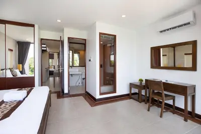 a bedroom with a bed and a desk and a bathroom at 3BR Pool Access Villa near Mission Hills Golf - Argent 7 in Ban Muang Mai