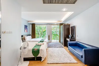 a bedroom with a bed and a blue couch at Villa Beverly Private Infinity Pool with Seaview near Kata Beach in Kata Beach