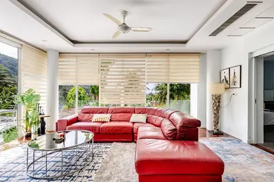 a living room with a red couch and a glass table at Villa Beverly Private Infinity Pool with Seaview near Kata Beach in Kata Beach