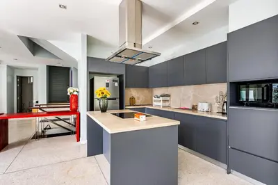 a kitchen with blue cabinets and a red counter top at Villa Beverly Private Infinity Pool with Seaview near Kata Beach in Kata Beach