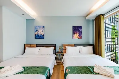 two beds in a room with blue walls and windows at Villa Beverly Private Infinity Pool with Seaview near Kata Beach in Kata Beach