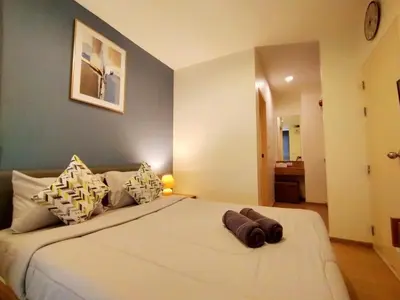 a bedroom with a large white bed with pillows at Cozy room near beaches & restaurants in Bang Tao Beach
