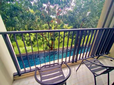 a balcony with two chairs and a swimming pool at Cozy room near beaches & restaurants in Bang Tao Beach