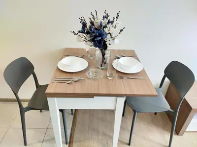 a wooden table with chairs and a vase of flowers at Cozy room near beaches & restaurants in Bang Tao Beach