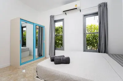 a bedroom with a bed and a large mirror at Sisters Ari 2-bedrooms house, Bang Tao beach in Ban Thalat Choeng Thale