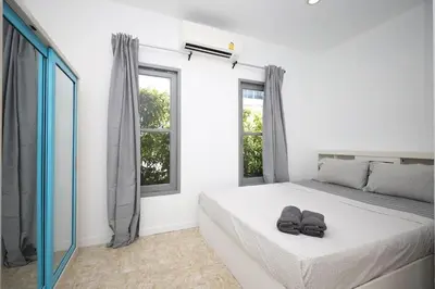 a bedroom with a bed with two slippers on it at Sisters Ari 2-bedrooms house, Bang Tao beach in Ban Thalat Choeng Thale