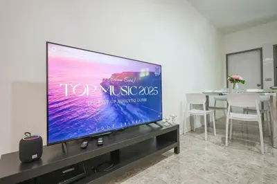 a large flat screen tv sitting on a entertainment center at Sisters Ari 2-bedrooms house, Bang Tao beach in Ban Thalat Choeng Thale