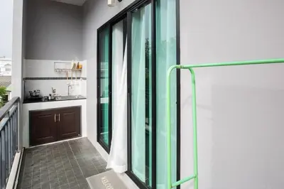 a balcony with glass doors on a building at Siam Condo Apartment, 600 metters to Bang Tao beach in Surin Beach