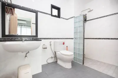 a bathroom with a toilet and a sink and a mirror at Siam Condo Apartment, 600 metters to Bang Tao beach in Surin Beach