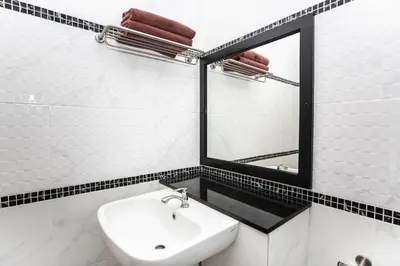 a white bathroom with a sink and a mirror at Siam Condo Apartment, 600 metters to Bang Tao beach in Surin Beach