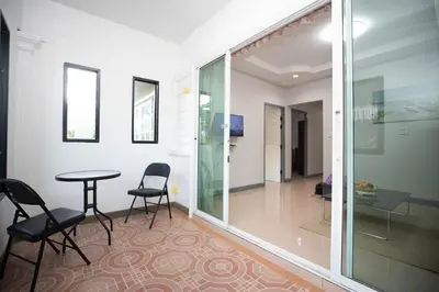 a room with a table and chairs and a glass door at SIRI apartments Bangtao beach in Ban Thalat Choeng Thale
