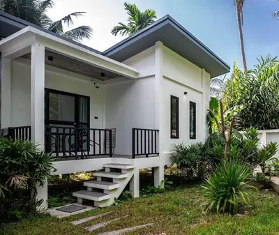 a white house with a staircase in front of it at SOMAN apartments Bang-Tao beach in Phuket Town