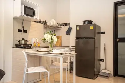 a kitchen with a small table and a refrigerator at SOMAN apartments Bang-Tao beach in Phuket Town