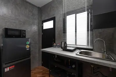 a small kitchen with a sink and a refrigerator at Sam's Unique and Stylish houses, 10 min to the beach in Ban Thalat Choeng Thale