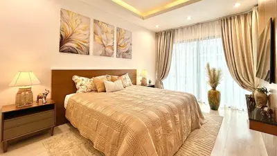 a bedroom with a bed and a large window at Stylish Family Townhouse 3 Bdr in Chalong