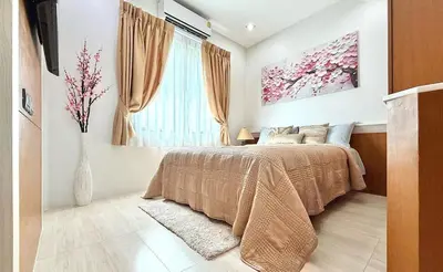 a bedroom with a bed and a vase with flowers at Stylish Family Townhouse 3 Bdr in Chalong