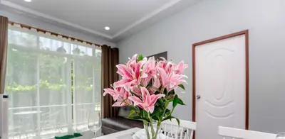 a vase filled with pink flowers sitting on a table at Tutu house, walking distanse to Bang Tao beach in Bang Tao Beach
