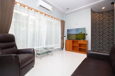 a living room with a couch and a flat screen tv at Tutu house, walking distanse to Bang Tao beach in Bang Tao Beach