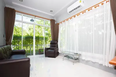 a living room with a couch and a chair and a window at Tutu house, walking distanse to Bang Tao beach in Bang Tao Beach
