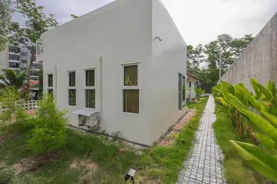 a white house with a cobblestone street at Japanese houses in Phuket in Ban Thalat Choeng Thale