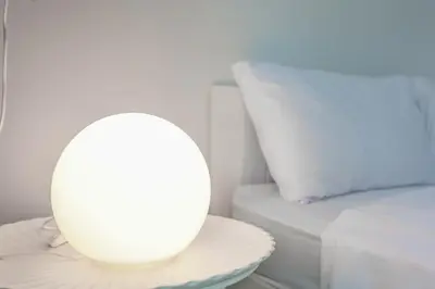 a white lamp sitting on a table next to a bed at Japanese barnhouse Bang Tao beach in Ban Thalat Choeng Thale