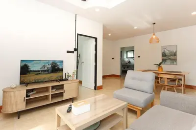 a living room with a tv and a couch and a table at Japanese barnhouse Bang Tao beach in Ban Thalat Choeng Thale