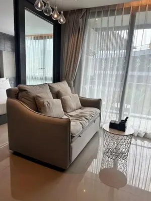 a couch sitting in a living room with windows at CityGate Kamala 1 bedroom By Ere L309 in Kamala Beach