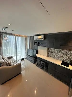 a living room with a couch and a kitchen at CityGate Kamala 1 bedroom By Ere L309 in Kamala Beach