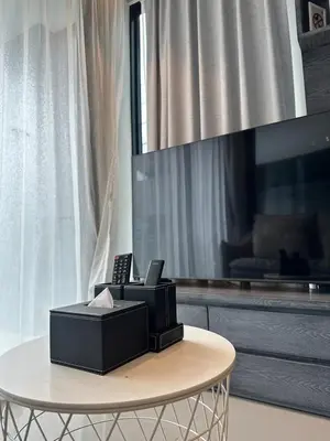 a black fax machine sitting on a table in a living room at CityGate Kamala 1 bedroom By Ere L309 in Kamala Beach