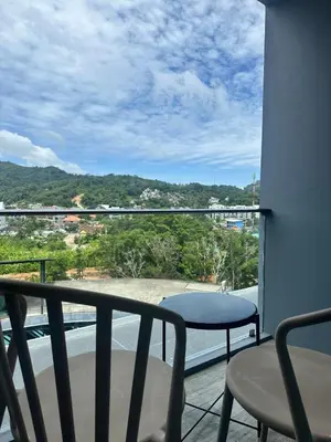 a balcony with a table and chairs and a view at CityGate Kamala 1 bedroom by Ere L807 in Kamala Beach