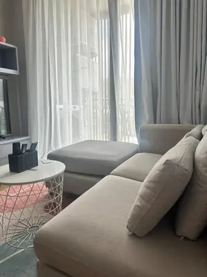 a living room with a couch and a window at CityGate Kamala 1 bedroom by Ere L807 in Kamala Beach