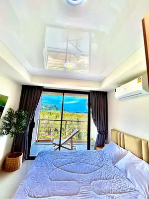 a bedroom with a large bed and a large window at Hillside-Seashore Space Mai Khao Beach in Mai Khao Beach