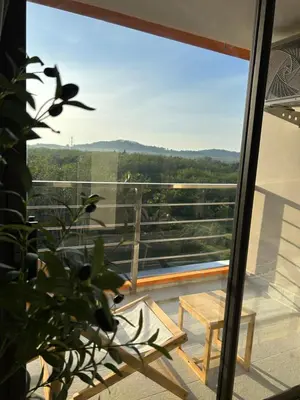 a view from the balcony of a house with a bench at Hillside-Seashore Space Mai Khao Beach in Mai Khao Beach