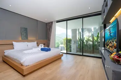 a bedroom with a large bed and a large window at Duplex Villa Natural Touch A2 2BR with scenic view and rooftop terrace in Kamala Beach