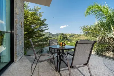 a patio with a table and chairs on a balcony at Duplex Villa Natural Touch A2 2BR with scenic view and rooftop terrace in Kamala Beach