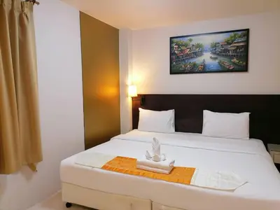 a hotel room with a bed with a statue on it at AtWhitePatong in Patong Beach