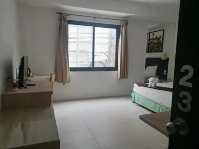 a bedroom with a bed and a window at AtWhitePatong in Patong Beach
